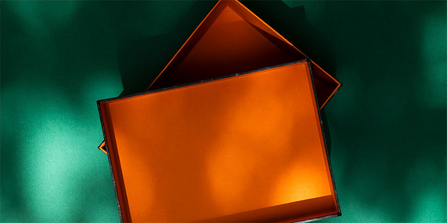 orange Schachtel auf grünem Untergrund